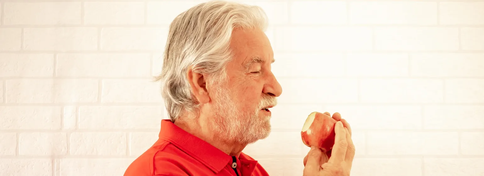 Senior man eating an apple