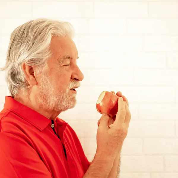 Senior man eating an apple